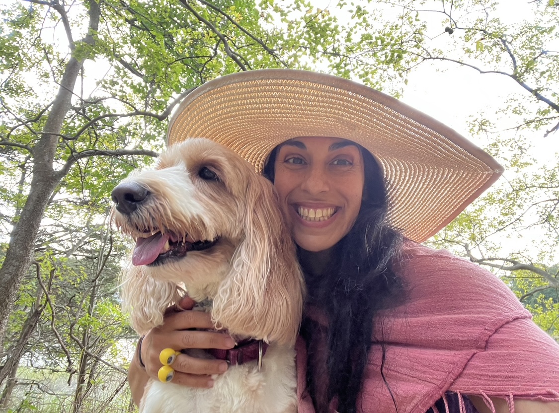 Aya smiling outdoors with her dog